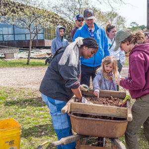 Visitors investigate the finds of a Surry County High School student as she screens for artifacts.