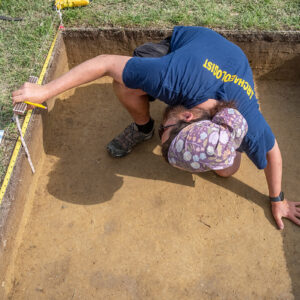 Archaeological Field Technician Josh Barber makes and records measurements related to one of the excavation squares in Smithfield.