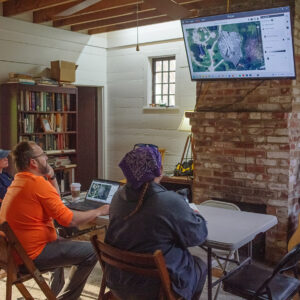 Staff Archaeologist Natalie Reid and Archaeological Field Technician Hannah Barch review ground-penetrating radar (GPR) data of the area north of the Memorial Church with Dr. David Leslie of TerraSearch Geophysical.
