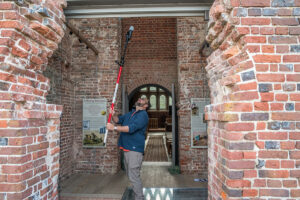 Dr. David Leslie of TerraSearch Geophysical uses a cellphone attached to a pole to take photographs of hard-to-reach portions of the 1680s Church Tower. The photographs will be reviewed for possible inclusion in a 3D model of the Tower and Memorial Church.