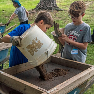 Campers screening soil from the excavations for artifacts