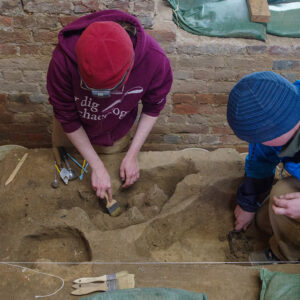 Staff Archaeologists Natalie Reid and Caitlin Delmas (L-R) at work in the Church Tower. Natalie is excavating sturgeon scutes found in the 1607 palisade wall trench.