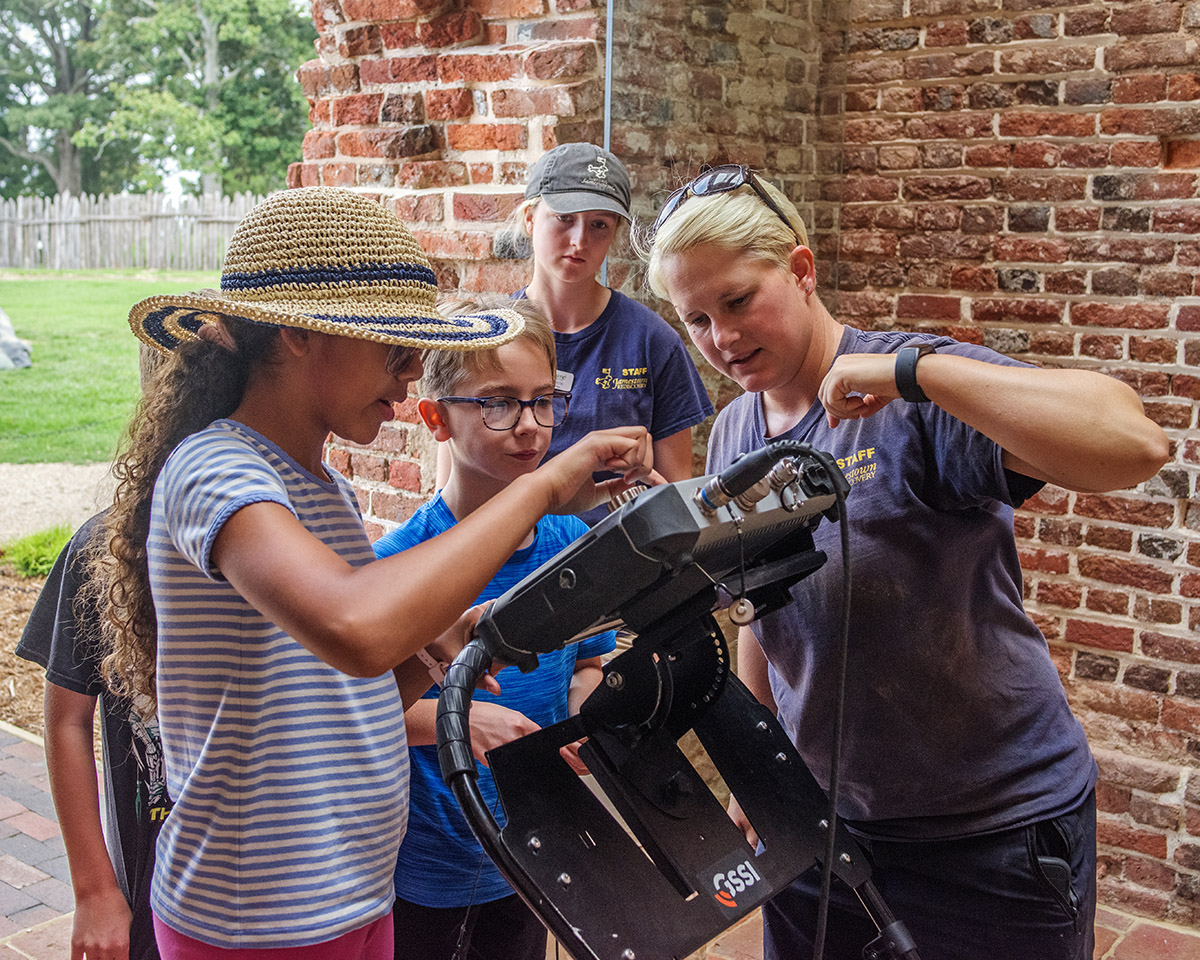 Staff Archaeologist Caitlin Delmas instructs campers in the use of the ground-penetrating radar (GPR) machine.