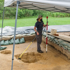 Archaeological Field Technician Ren Willis surveys one of the subfloor pits in the north field.