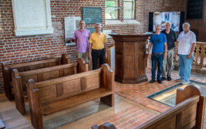 Members of Ford's Colony Woodworkers stand with the pulpit they created.