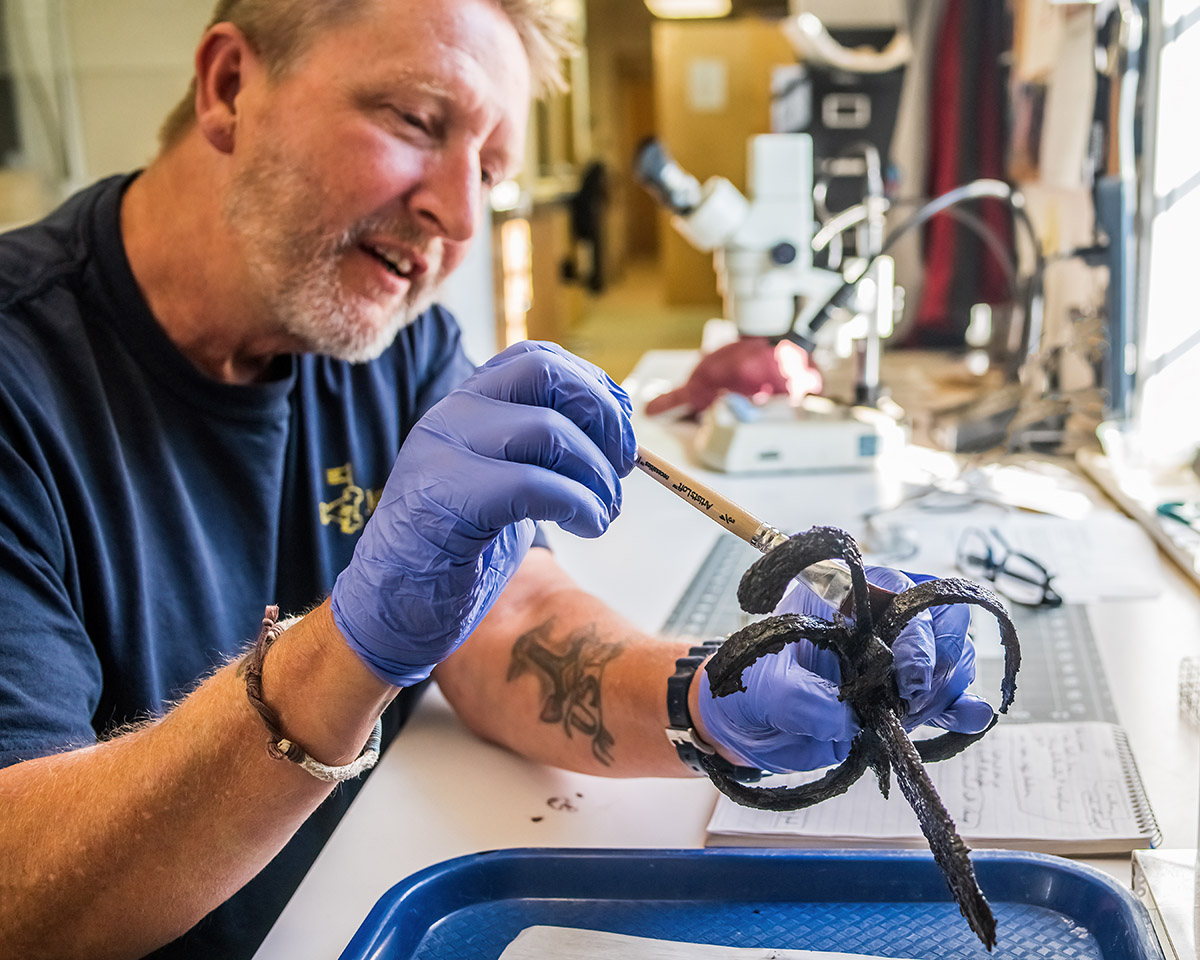 Senior Conservator Dan Gamble applies tannic acid to the Governor's Well sword he's conserving.