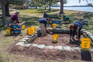 Archaeological Field Technicians Eleanor Robb, Josh Barber, Ren Willis, and Hannah Barch excavate one of the new squares just southwest of the Archaearium.