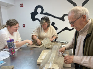 Assistant Curator Magen Hodapp reviews faunal material from layer "N" of the John Smith Well with outside zooarchaeologists Susan Andrews and Steve Atkins.