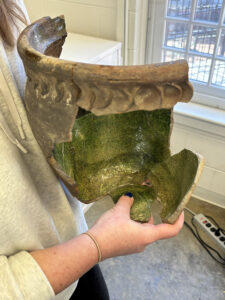 Senior Curator Leah Stricker holds the London post-medieval redware vessel with the new crossmend sherd in her right hand.