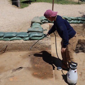 Staff Archaeologist Caitlin Delmas sprays features from the north Church Tower excavations to make them stand out against the surrounding soil.