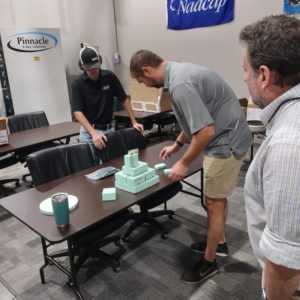 Pinnacle's Cameron Ward and Jake Rickter prepare a stage for the chain armor as Conservator Dr. Chris Wilkins looks on.