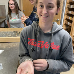 Field School student Ren Willis holds a sherd of a celadon bottle she found during sorting.