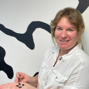 Curator Leah Stricker holds some of the plum stones found in the Governor's Well.