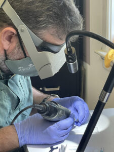 Dr. Chris Wilkins extracts a sample from one of Jamestown's jet artifacts for isotopic analysis .