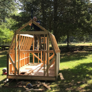 Archaeologist constructing a wooden shed