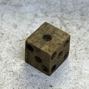 A bone die found by Associate Curator Emma Derry while picking through material from the fort's first well
