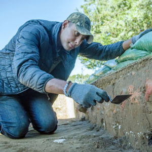 Kalen Anderson points to brick rubble in a test unit’s profile, which is likely related to the construction of the Church Tower.