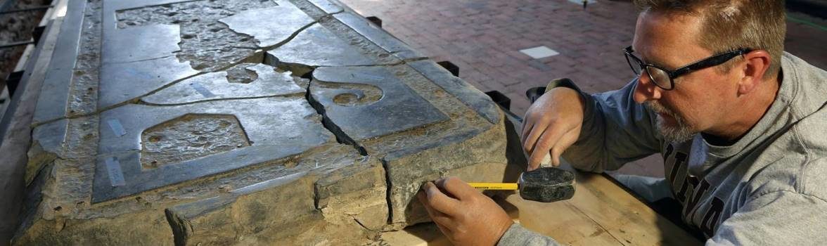 Conservator measuring a large tombstone