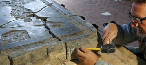 Conservator measuring a large tombstone