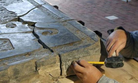 Conservator measuring a large tombstone