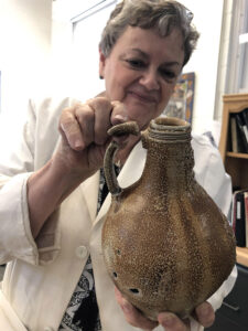 Senior Curator Merry Outlaw with a Bartmann jug