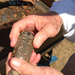 hand holding a glass bottle with stamped lettering