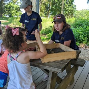 Some young visitors learning about artifacts at the Ed Shed