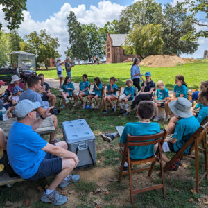 The campers share the experiences of Kids Camp with their families. Staff Archaeologist Natalie Reid leads the discussion.