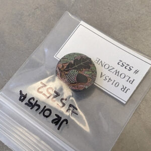 A Victorian-era carnival glass button bearing an oak leaf and acorn.