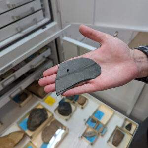 A Virginia Indian slate gorget. The gorget is a modified ulu, a type of knife. Note the hole used to hang the gorget around one's neck.