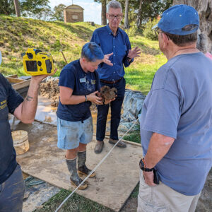 Staff Archaeologist Caitlin Delmas shares the sword hilt she found while water screening with visitors. President of the Jamestown Rediscovery Foundation Dr. Jim Horn describes the artifact to the visitors.