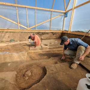 Senior Staff Archaeologist Dr. Churck Durfor photographs features in the burial structure while Senior Staff Archaeologist Sean Romo carefully scrapes away soil just south of one of the burials.