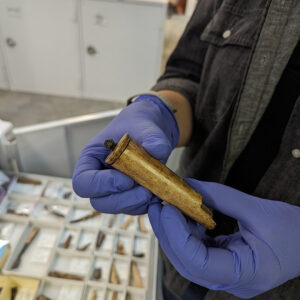 Senior Curator Leah Stricker holds a bone handle for a whittle tang knife.