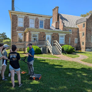 Senior Staff Archaeologist Sean Romo explains the plan of action for the GPR survey of Bacon's Castle to the field school students.