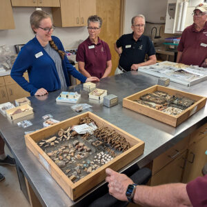 Associate Curator Janene Johnston shares some of the latest finds with volunteers.