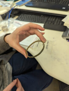 A copper alloy ring -- possibly a bracelet -- found near the Memorial Church. This is one of the artifacts being gathered for inclusion in the interim report for 2020-2023.