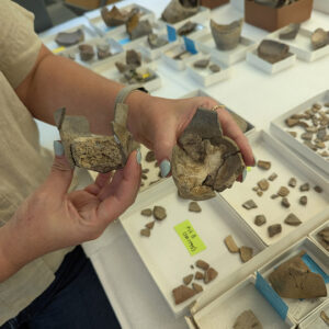 Senior Curator Leah Stricker holds two crucibles containing lead residue.