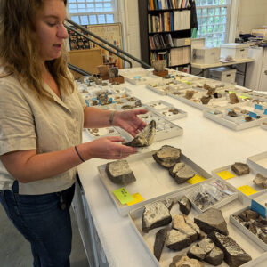 Senior Curator Leah Stricker holds a fragment of a melting pot in the Jamestown collection.