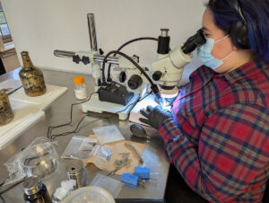 Assistant Conservator Jo Hoppe conserves window leads with help from one of the new microscopes.