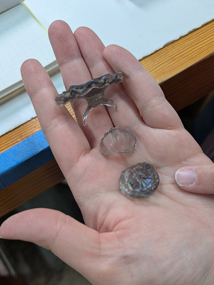Assistant Curator Lindsay bliss points to the new stem piece of John Greene wine glass found by a volunteer.