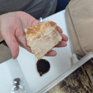 Assistant Curator Lauren Stephens holds a piece of interior plaster from the 1617 church. This side would have faced the interior of the Church.