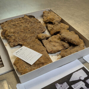 Pieces of a 19th-century gas stove are unrecognizable encrusted in soil and corrosion