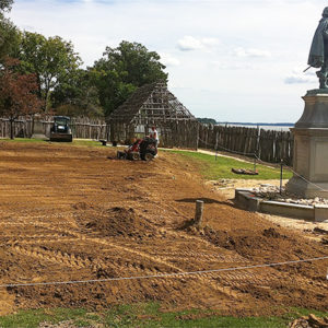 portion of a field behind a statue of John Smith covered in newly-laid soil