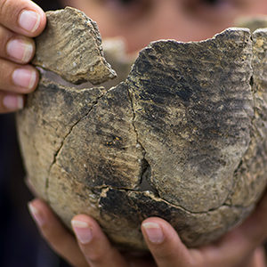 Hands holding a stamped Virginia Indian clay pot