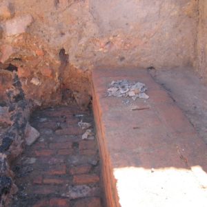 Glass shards piled on an excavated brick wall