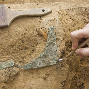 pick being used to excavate a copper artifact