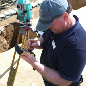 man making a note on a handheld digital transit unit