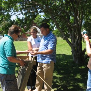 Visitors examine artifacts in a screen