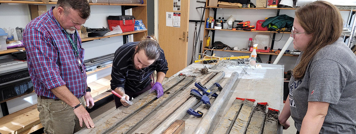 Director of Archaeology David Givens, Preston Senderoff, and graduate student Stephanie Scialo inspect the sediment in the core sample.