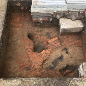 Segment of an exposed brick path and other features within an excavation unit